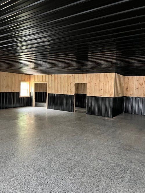 A large empty room with wooden walls and a black ceiling.
