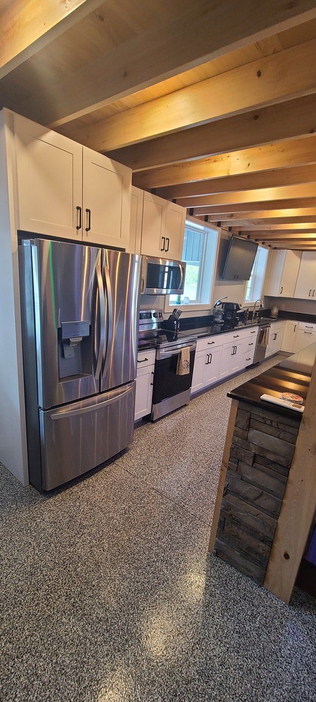 A kitchen with stainless steel appliances and white cabinets.