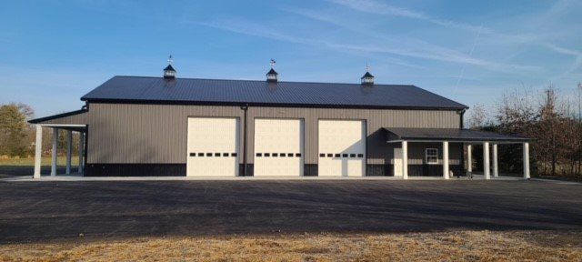 A large building with a black roof and white garage doors