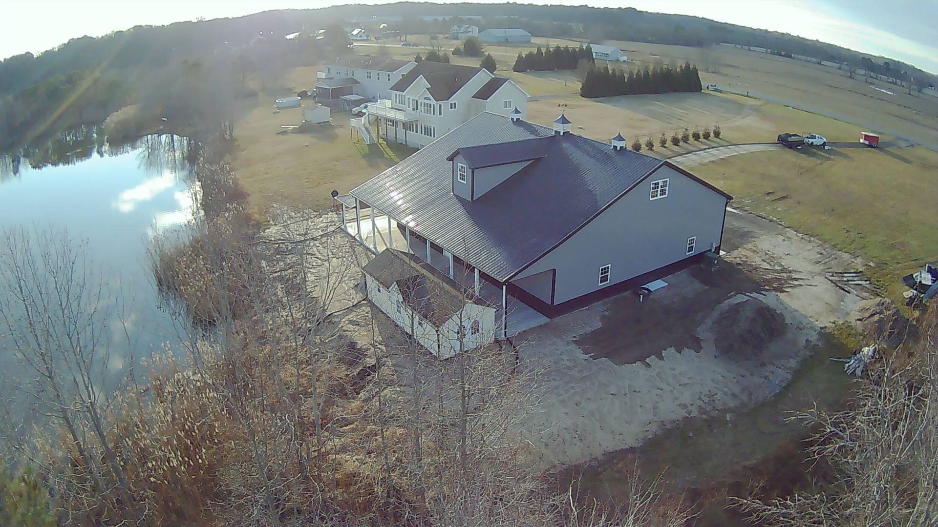An aerial view of a house next to a body of water