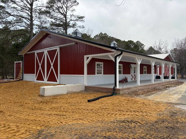 A large red and white barn with a porch