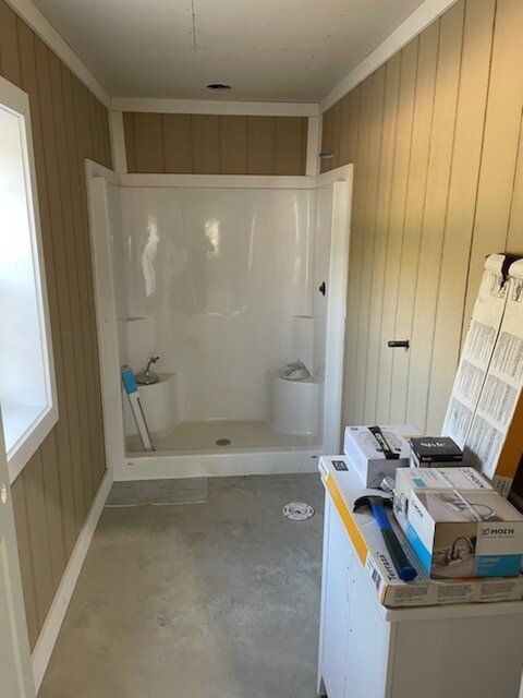 A bathroom with a shower and a washer and dryer.