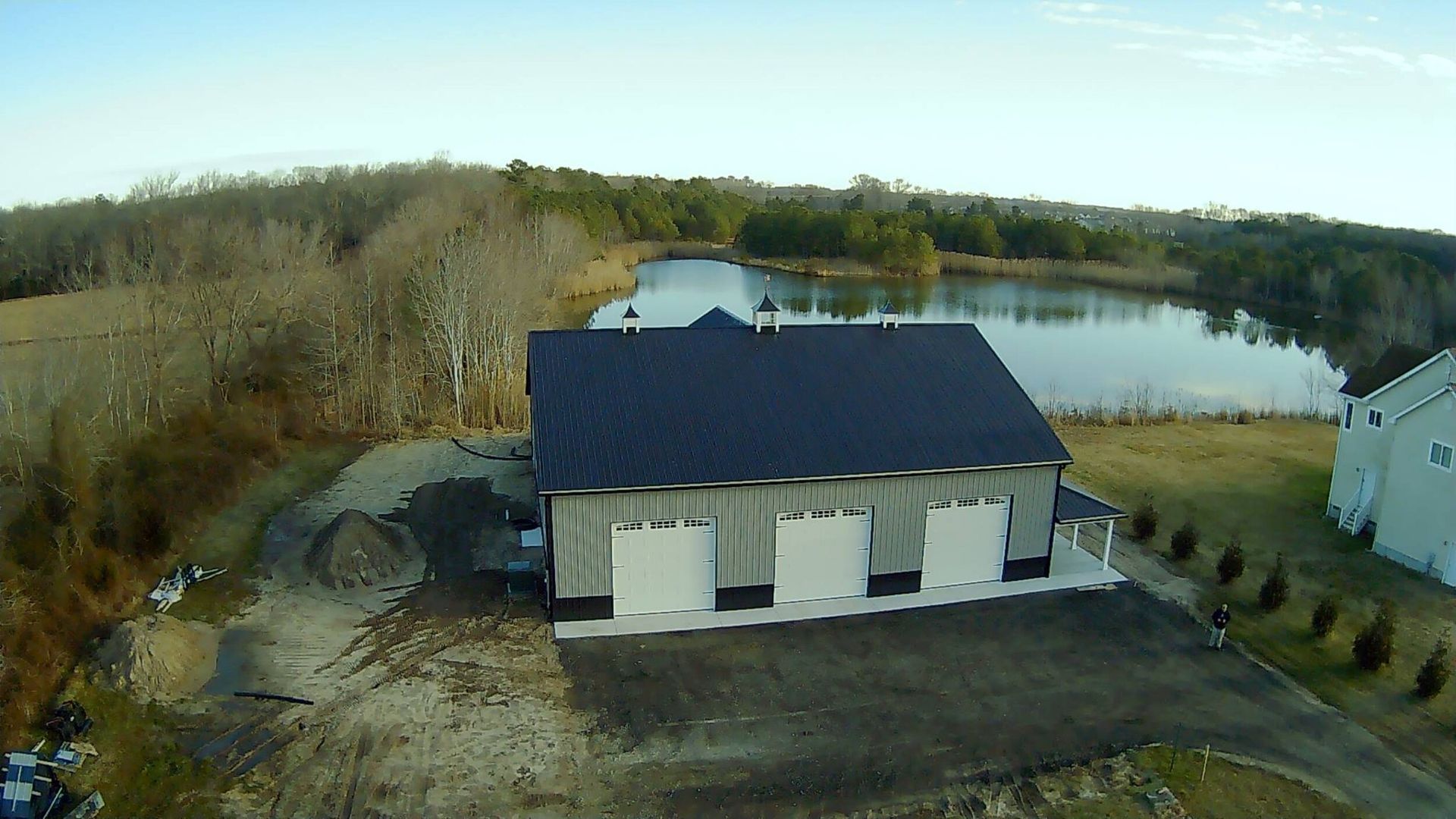 An aerial view of a house next to a lake