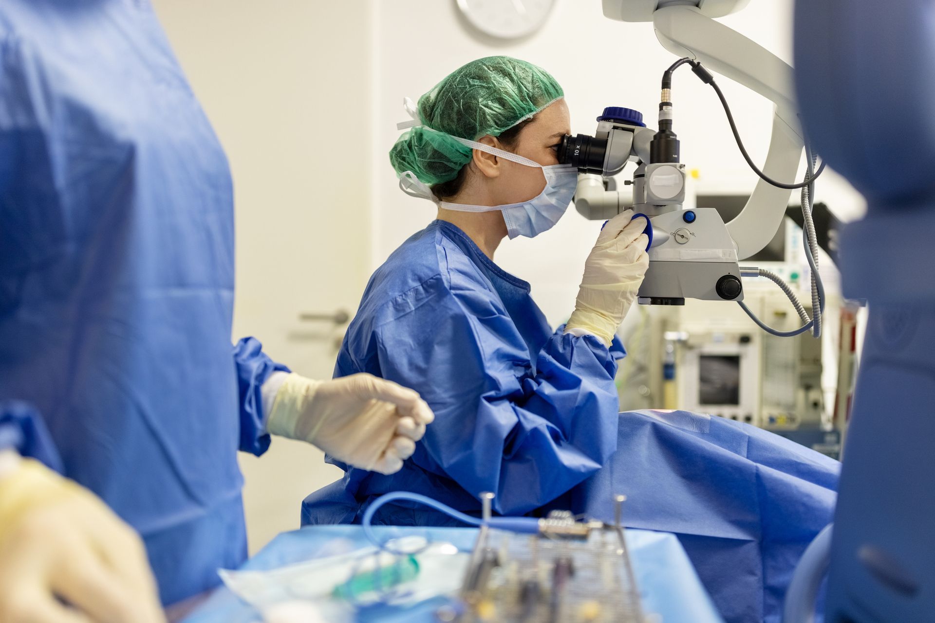 Professional ophthalmologist performs eye surgery with a microscope in modern clinic.
