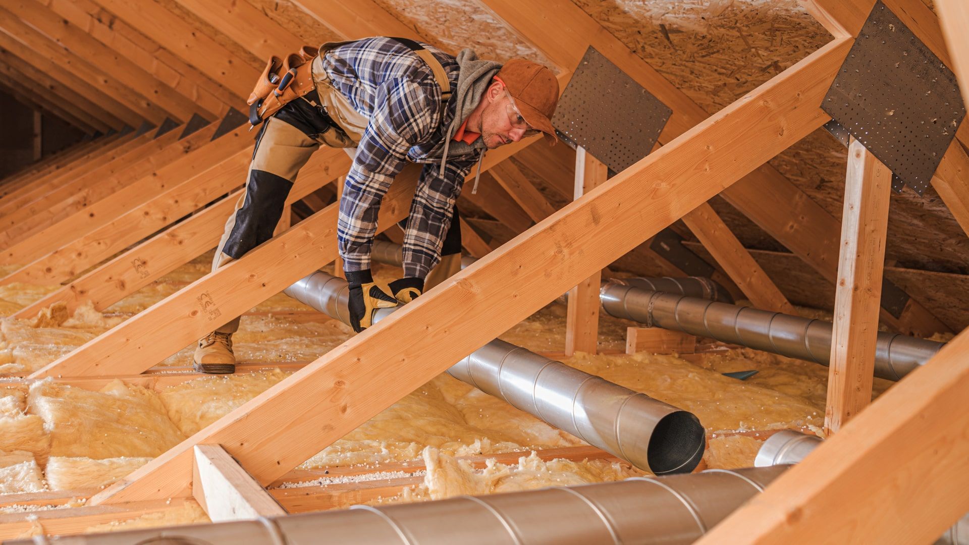 A man is working on the attic of a house.