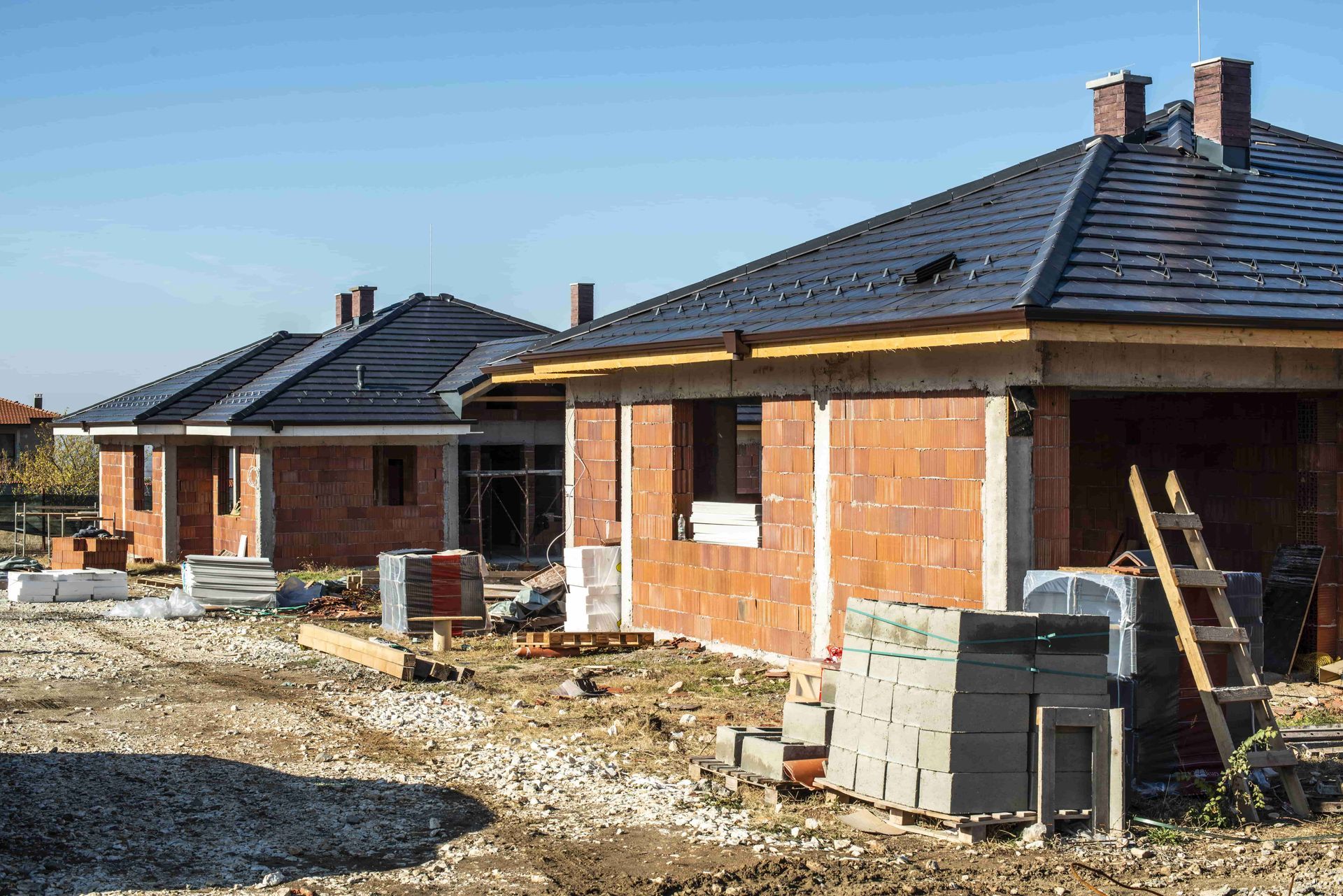 A row of brick houses under construction in a residential area.