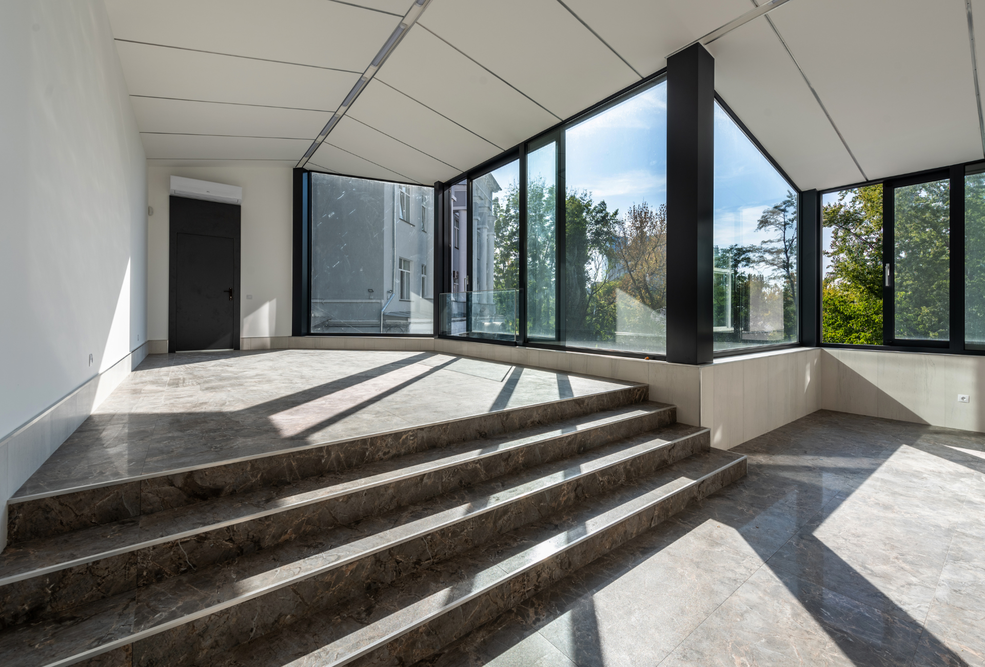 An empty room with stairs and a lot of windows