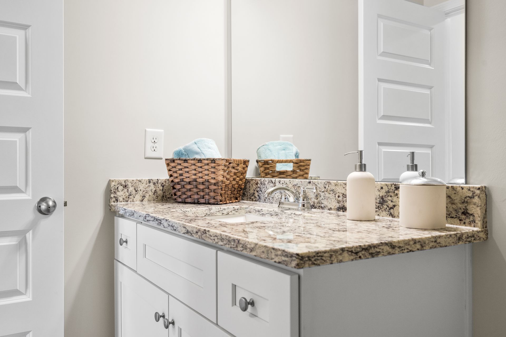 A bathroom with a sink , mirror and towels on the counter.