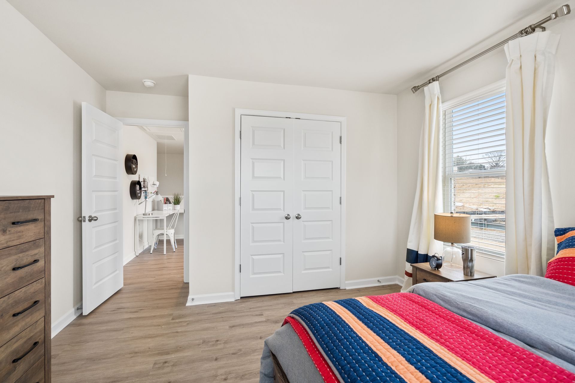 A bedroom with a bed , dresser , and closet.