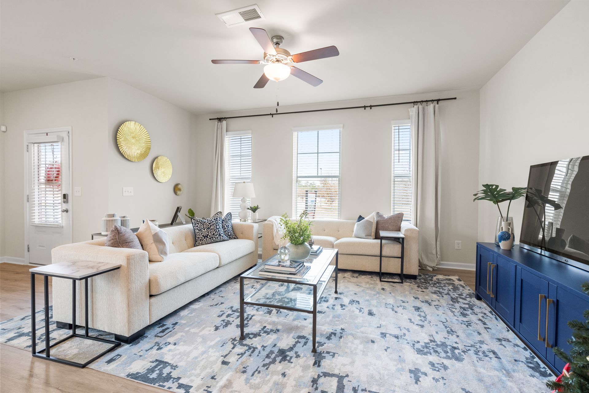 A living room with two couches , a coffee table , and a ceiling fan.