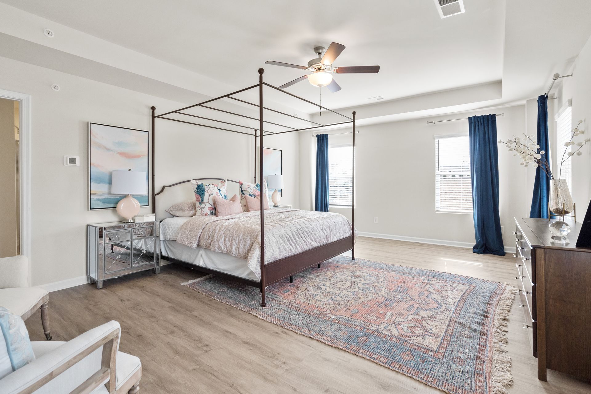 A bedroom with a canopy bed and a ceiling fan.