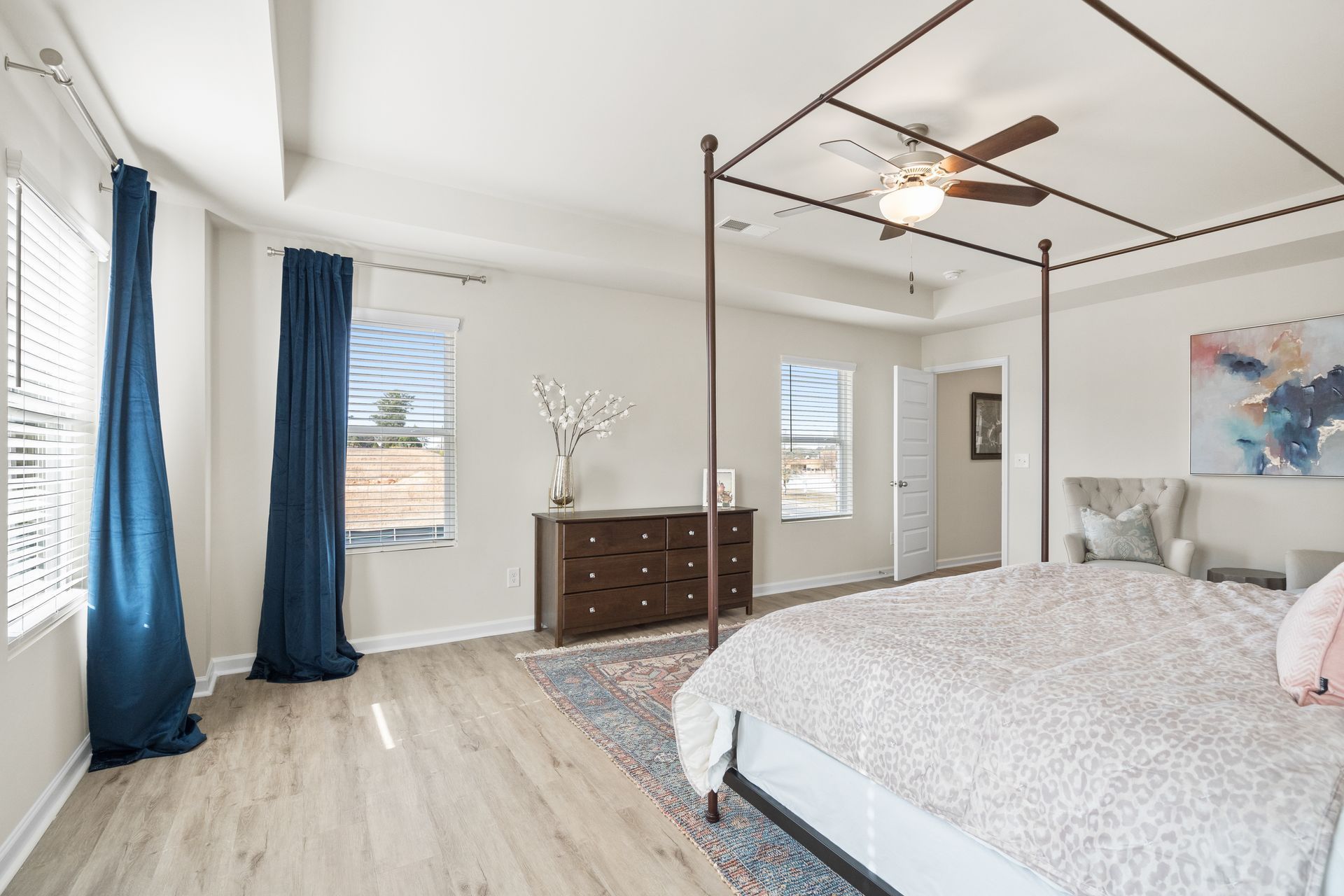 A bedroom with a canopy bed and a ceiling fan.