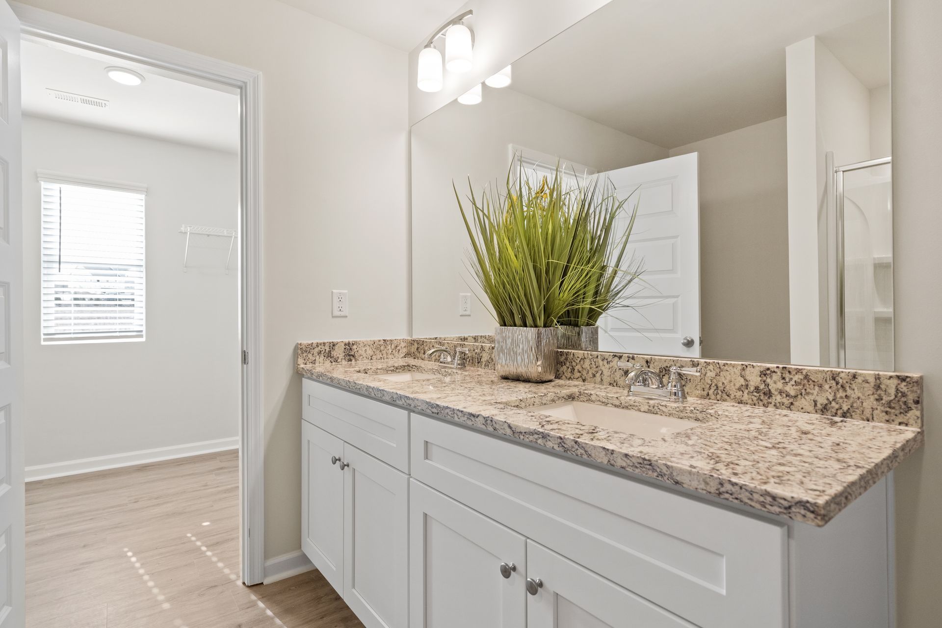 A bathroom with a double sink and a large mirror.