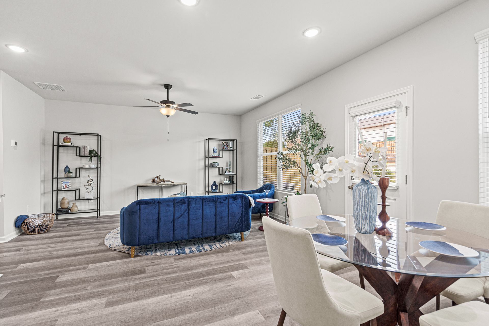 A living room with a blue couch and a dining table.