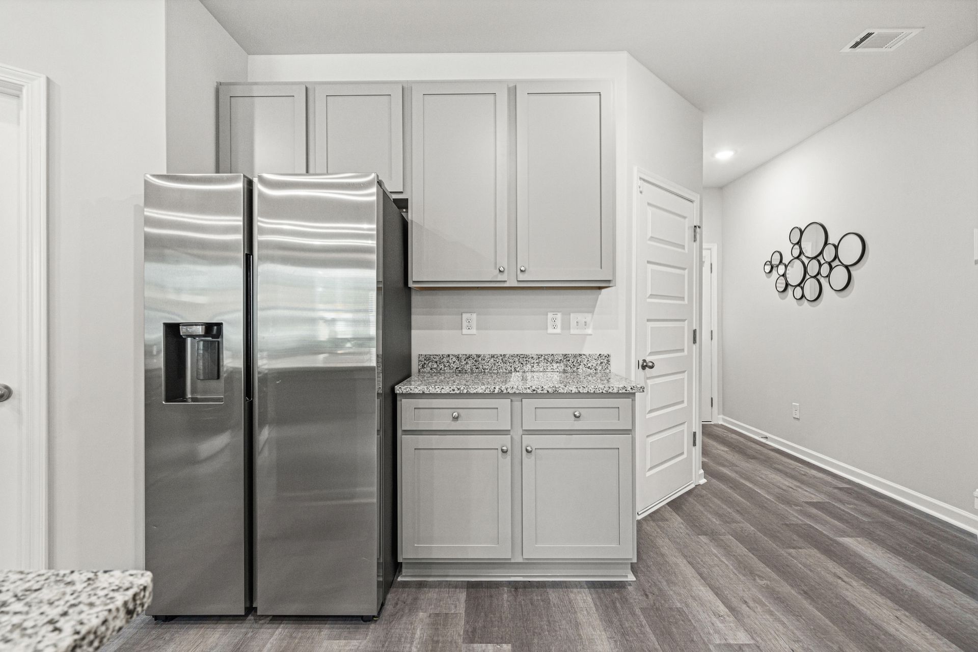 A kitchen with stainless steel appliances and gray cabinets.