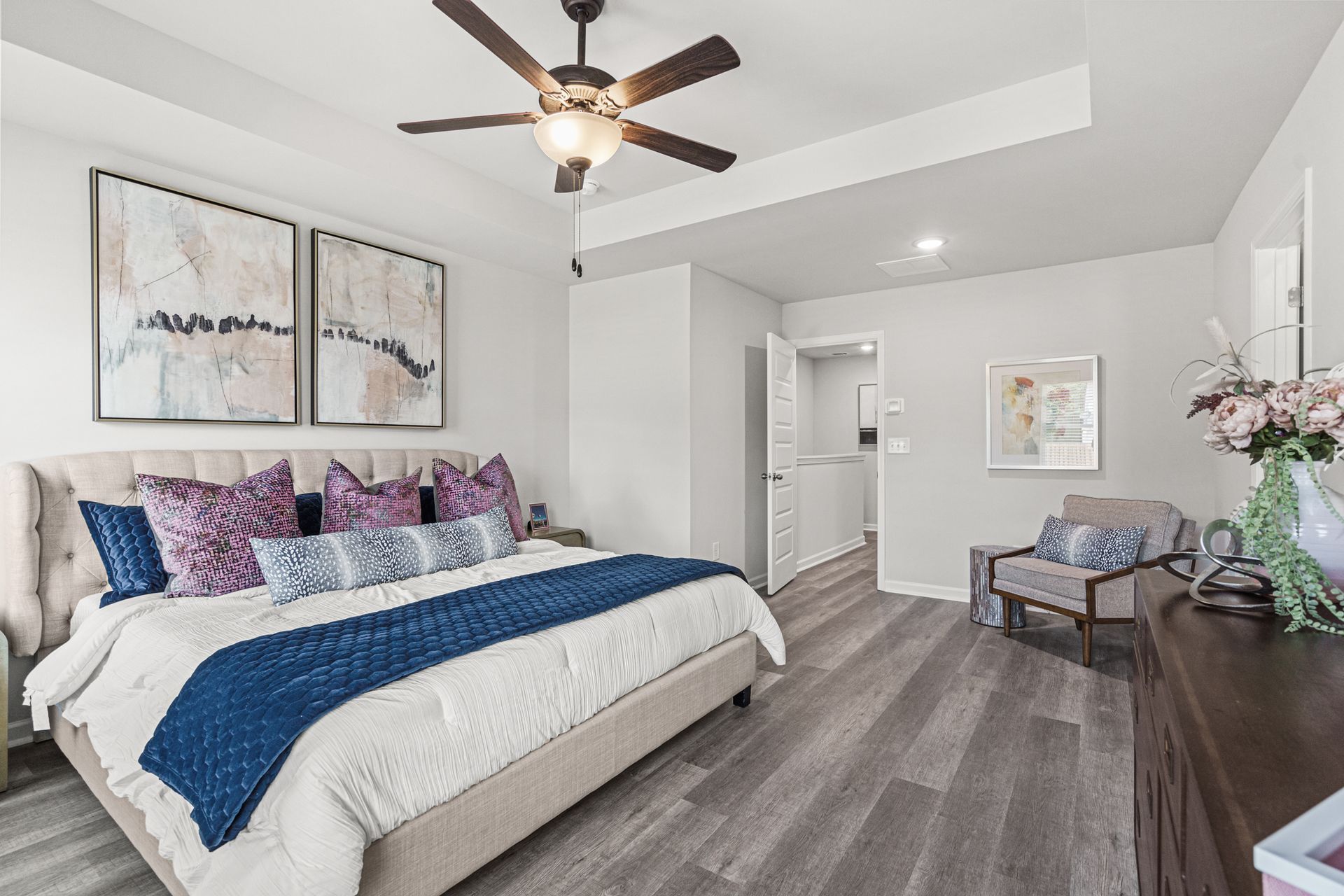 A bedroom with a large bed and a ceiling fan.