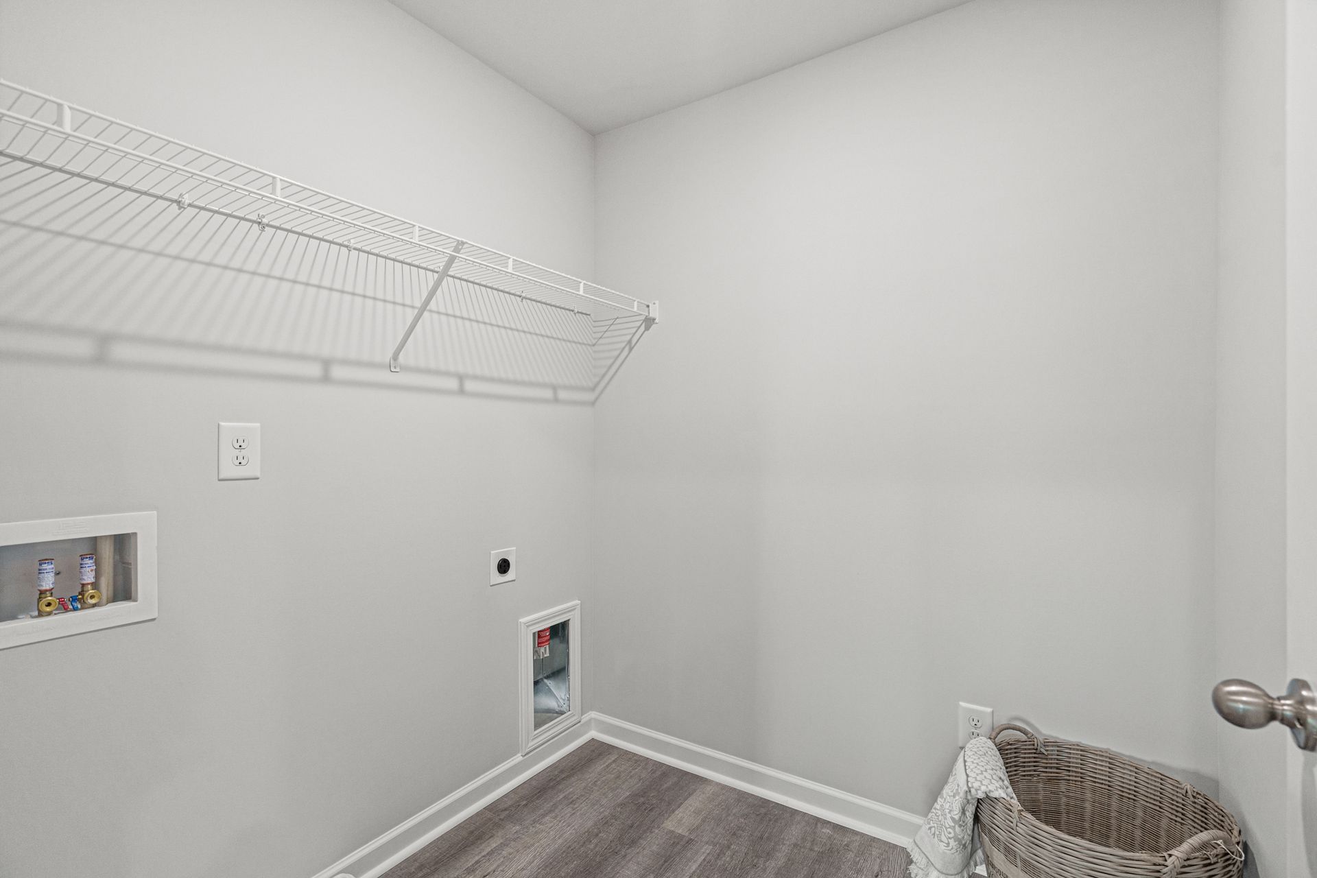 A laundry room with a washer and dryer and a basket.