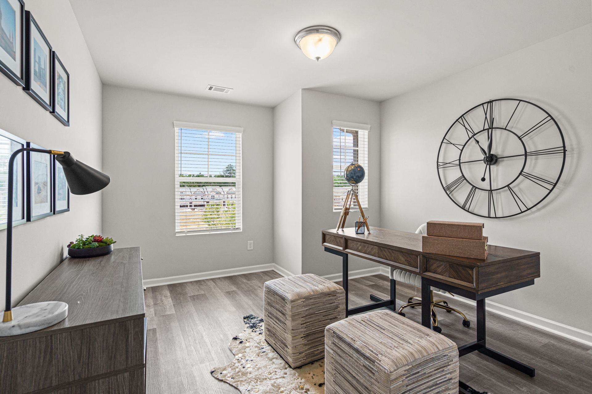 A home office with a desk and a clock on the wall.