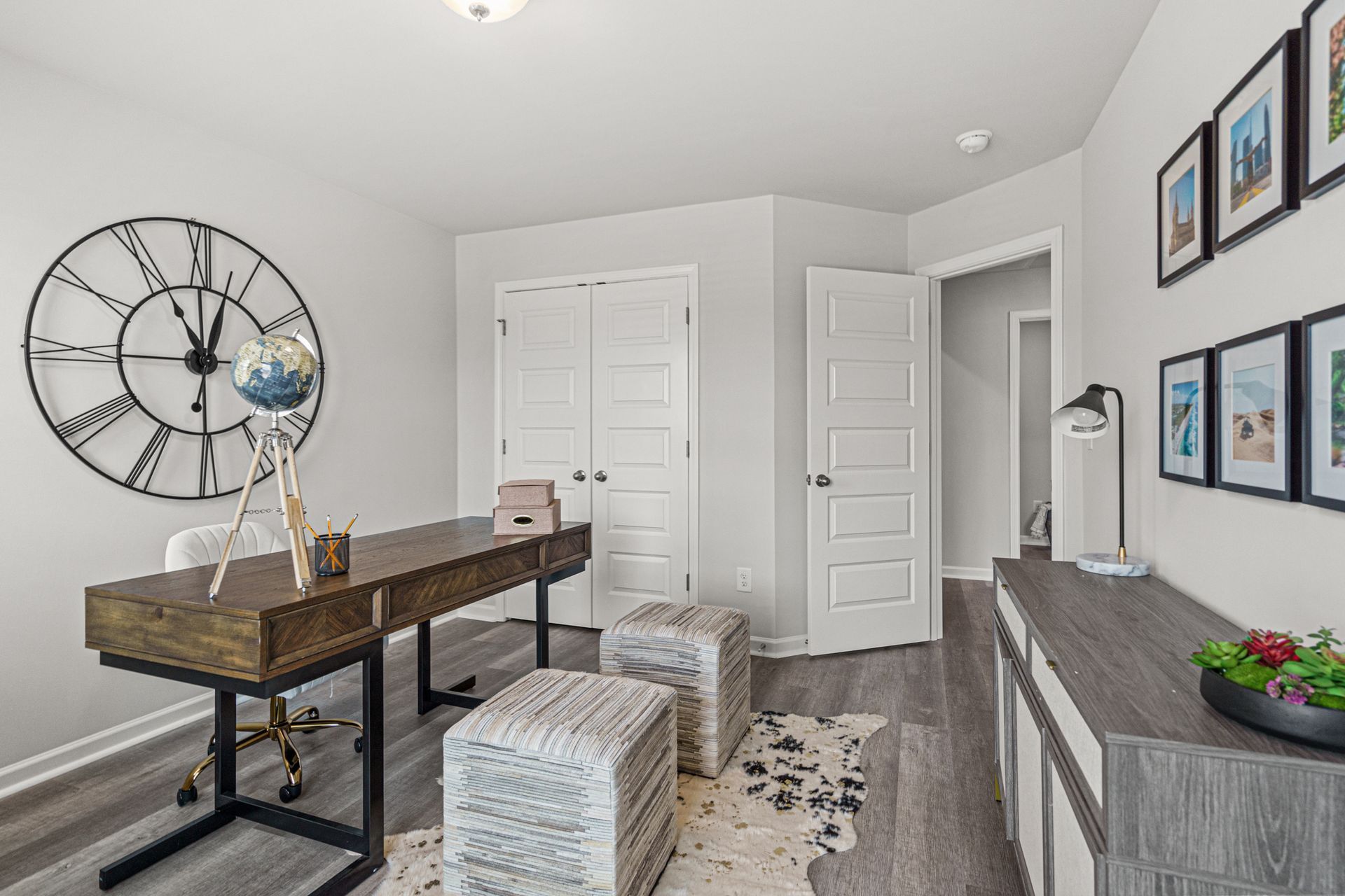 A home office with a desk and a clock on the wall.