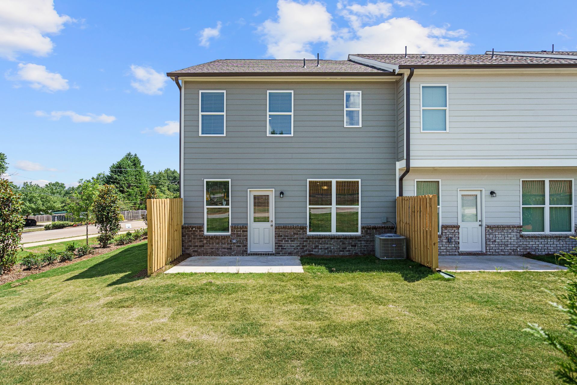 The back of a house with a large lawn in front of it.