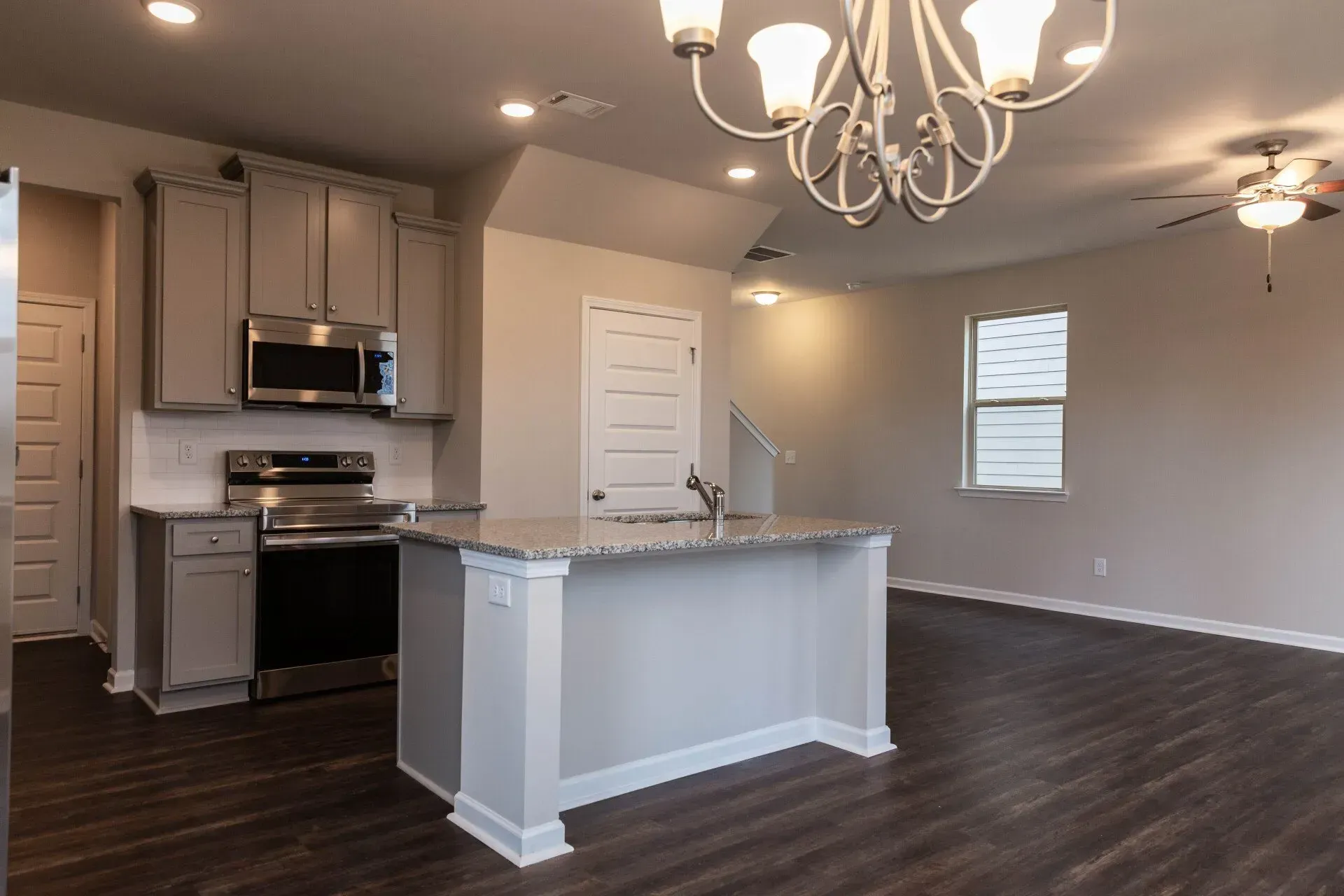 An empty kitchen with a large island in the middle of the room.