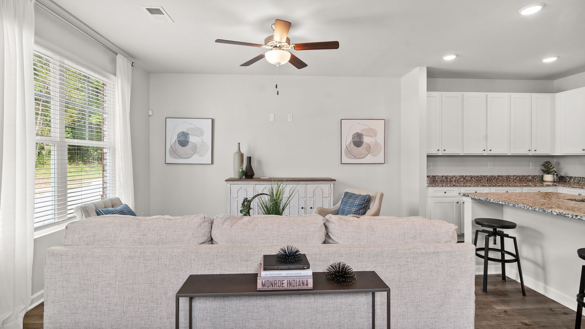 A living room with a couch and a ceiling fan.