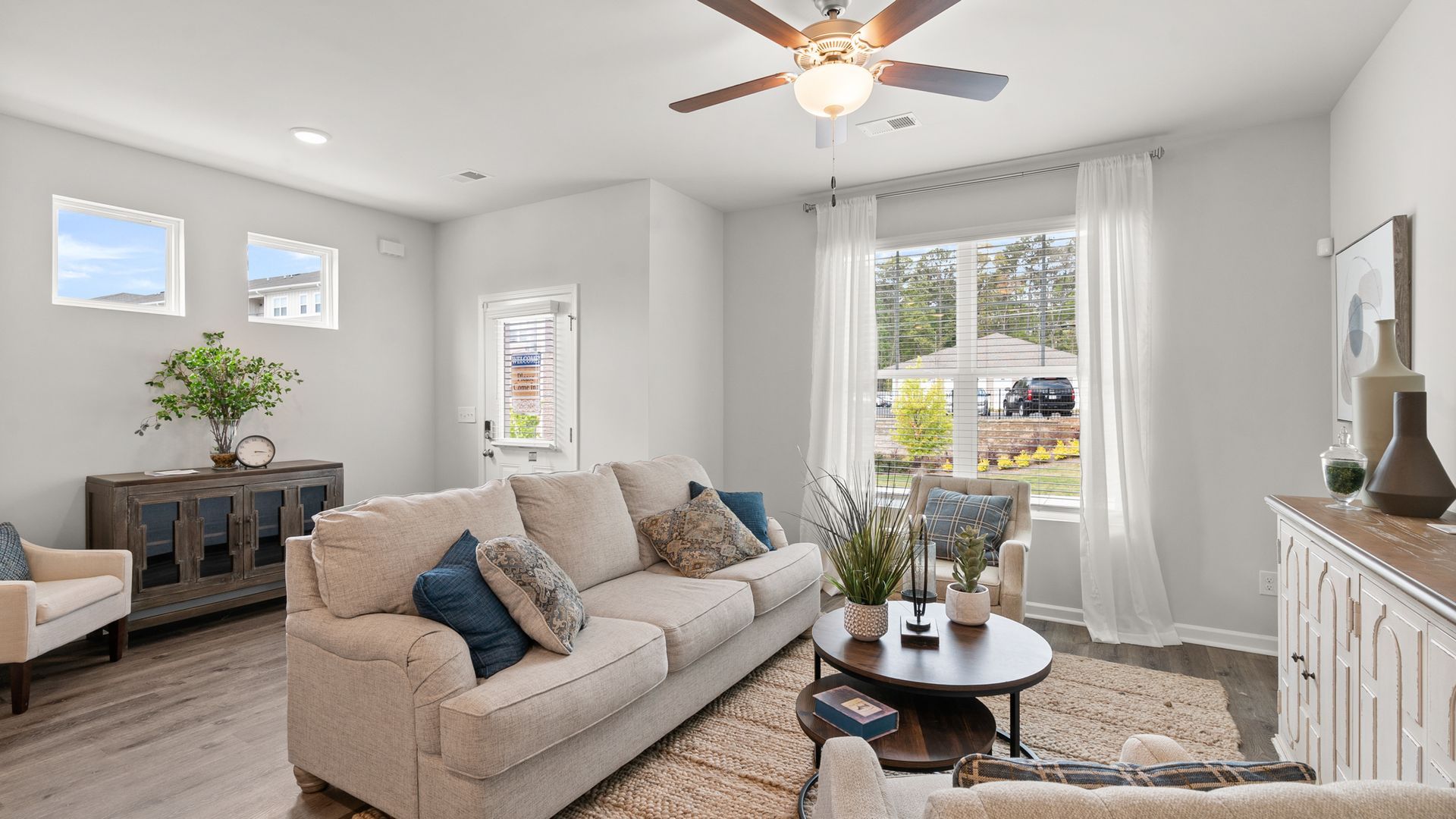 A living room with a couch , chairs , and a ceiling fan.