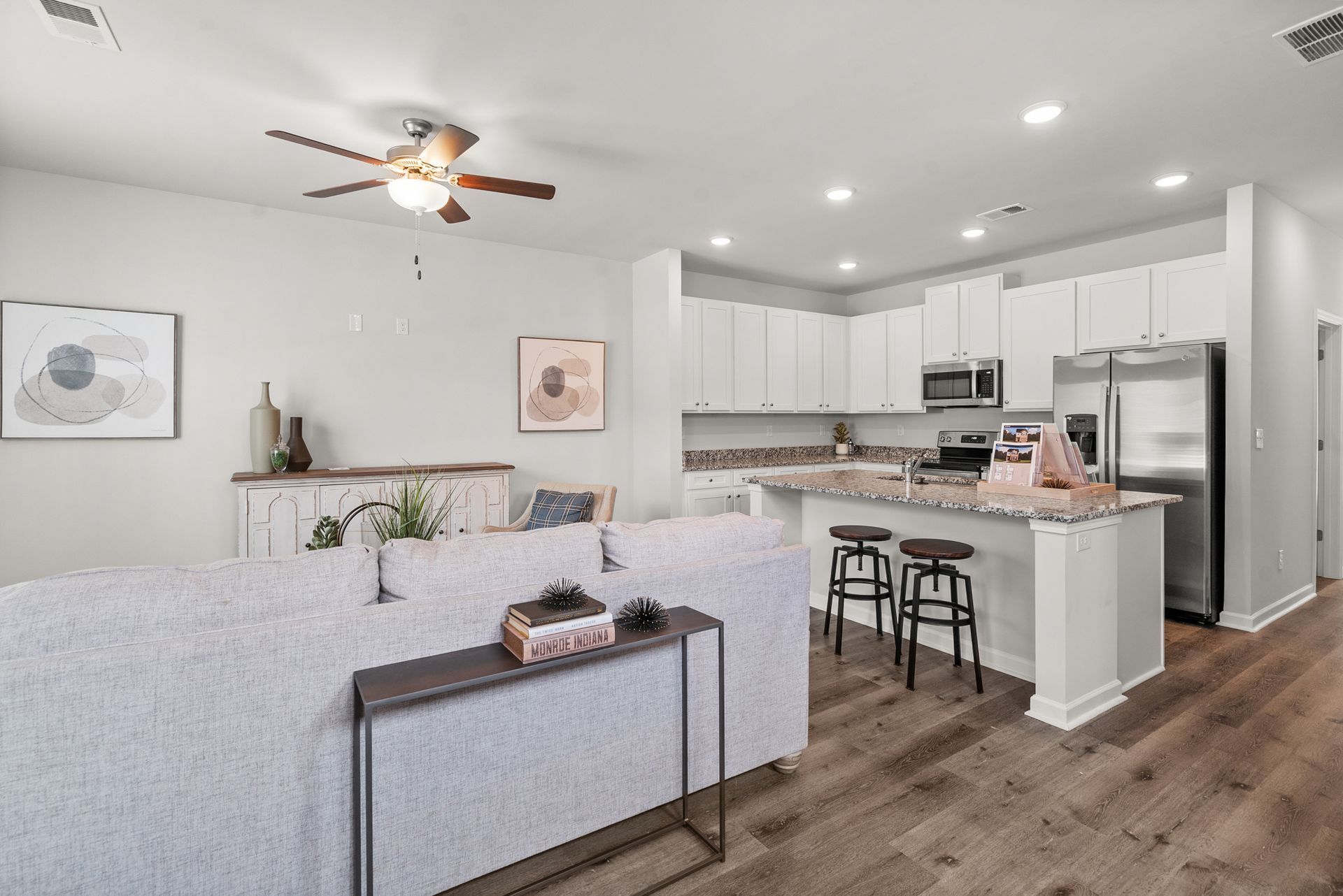 There is a ceiling fan in the living room and a kitchen.