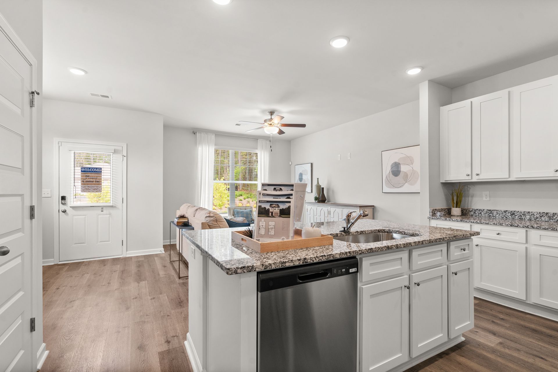 A kitchen with white cabinets , granite counter tops , and stainless steel appliances.