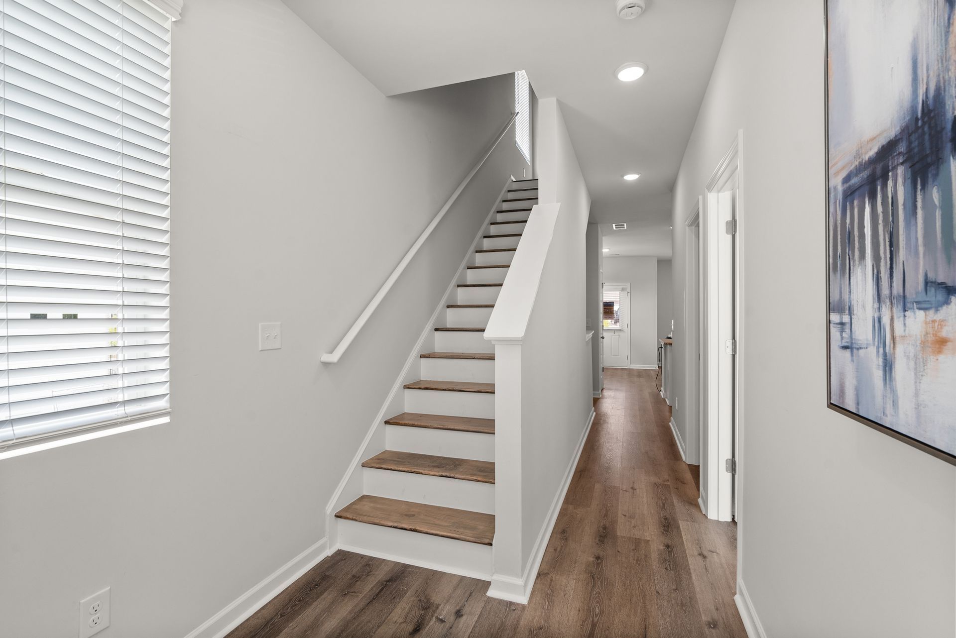 A hallway with stairs leading up to the second floor of a house.