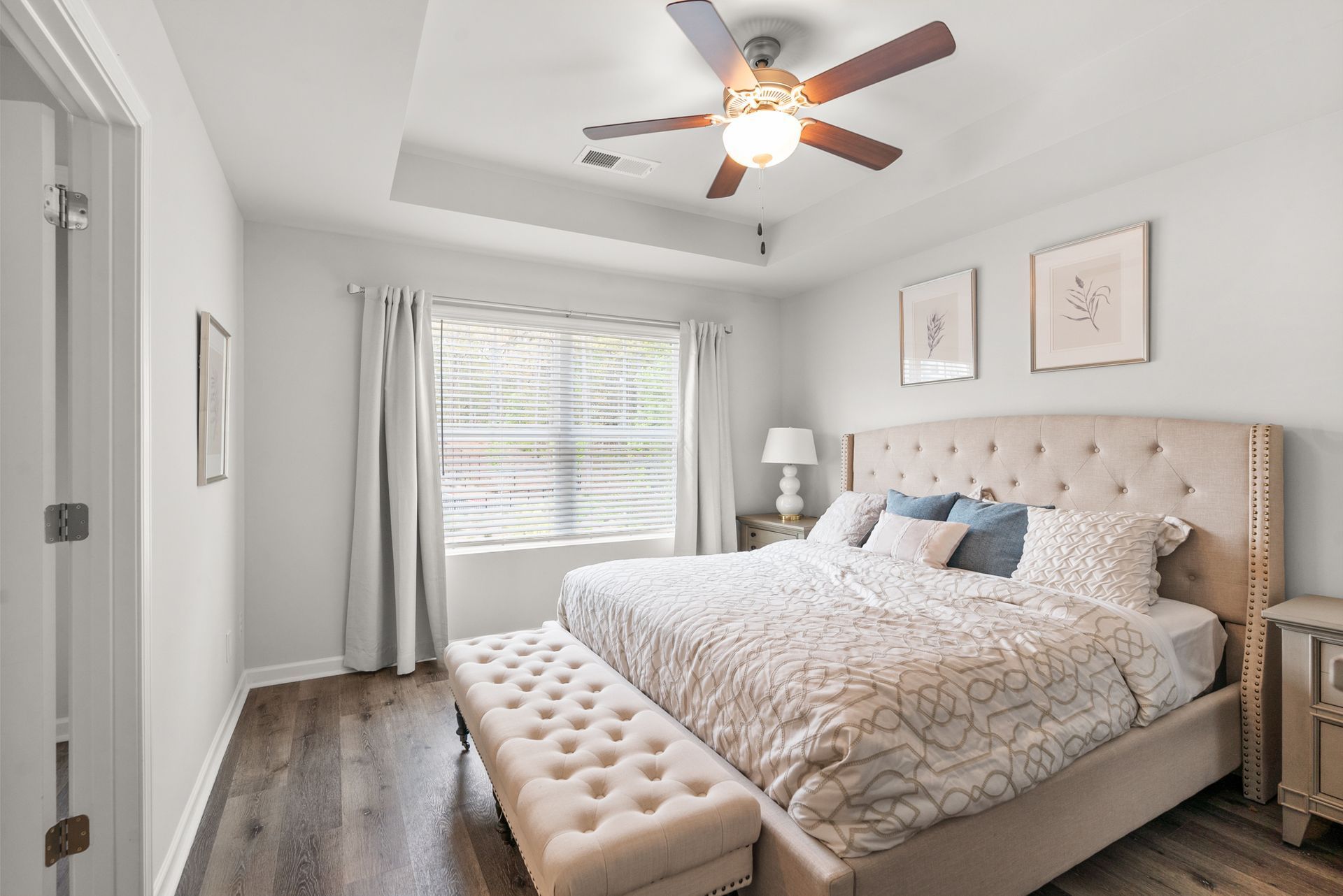 A bedroom with a large bed and a ceiling fan.