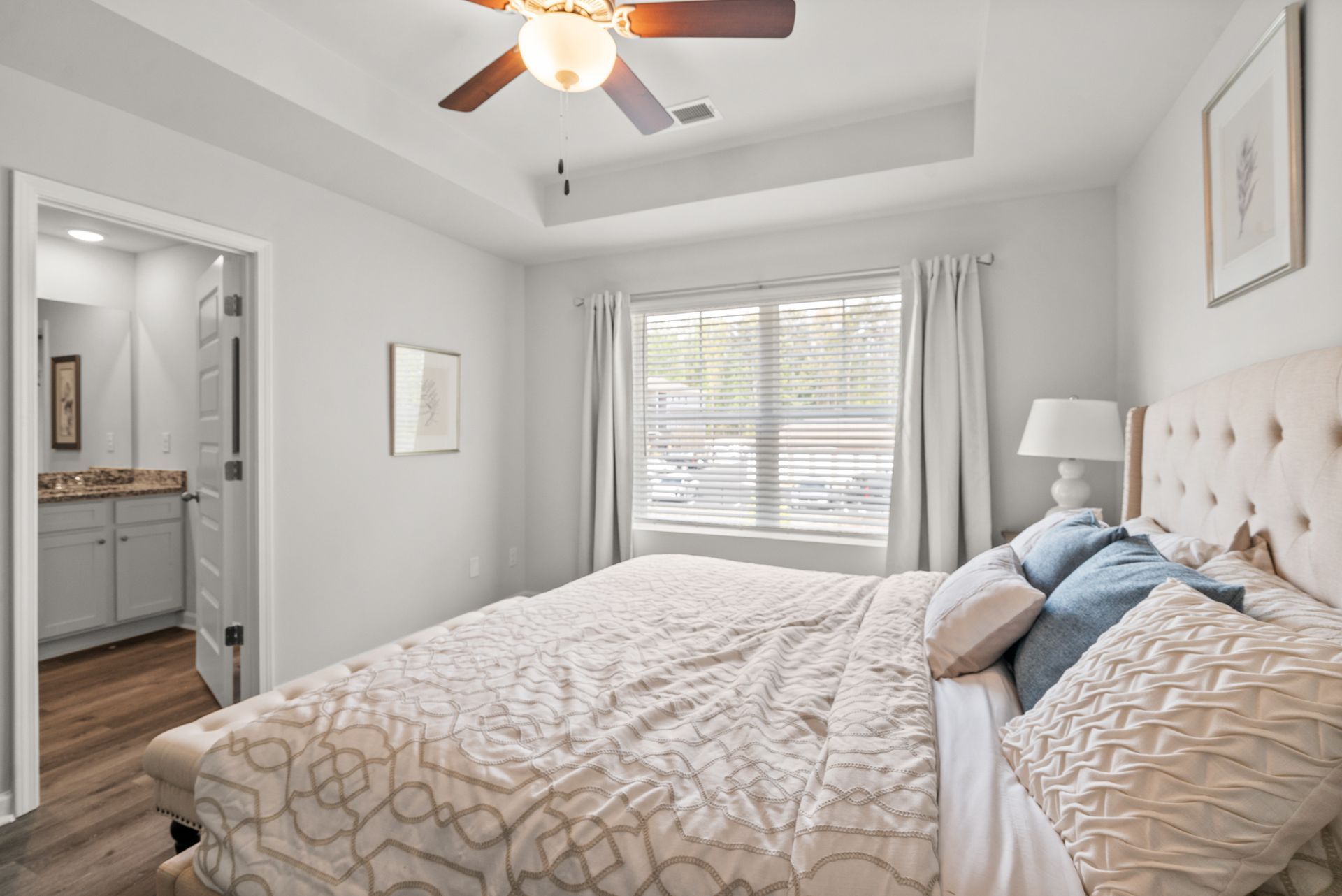 A bedroom with a king size bed and a ceiling fan.