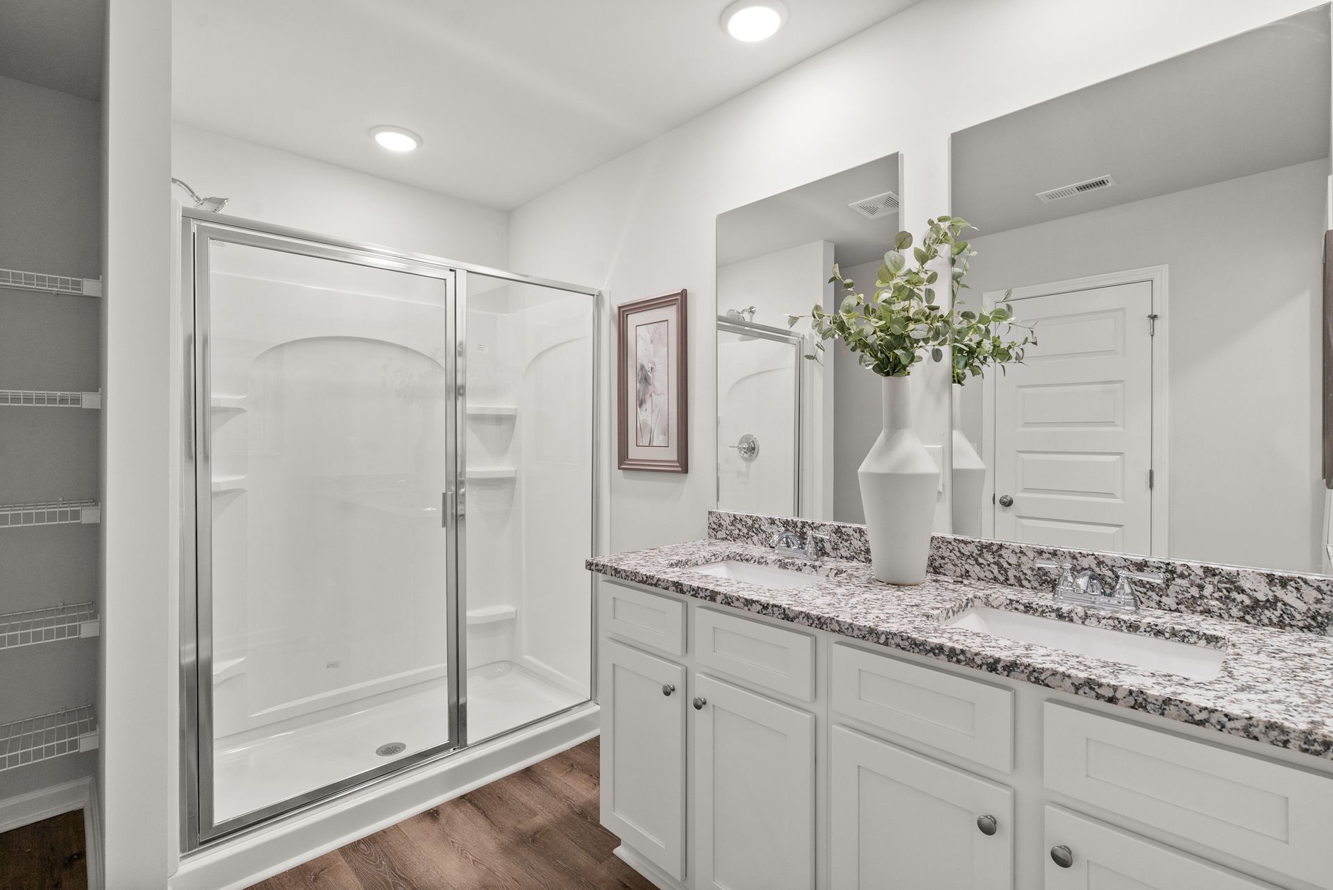 A bathroom with a walk in shower , sink , and mirror.