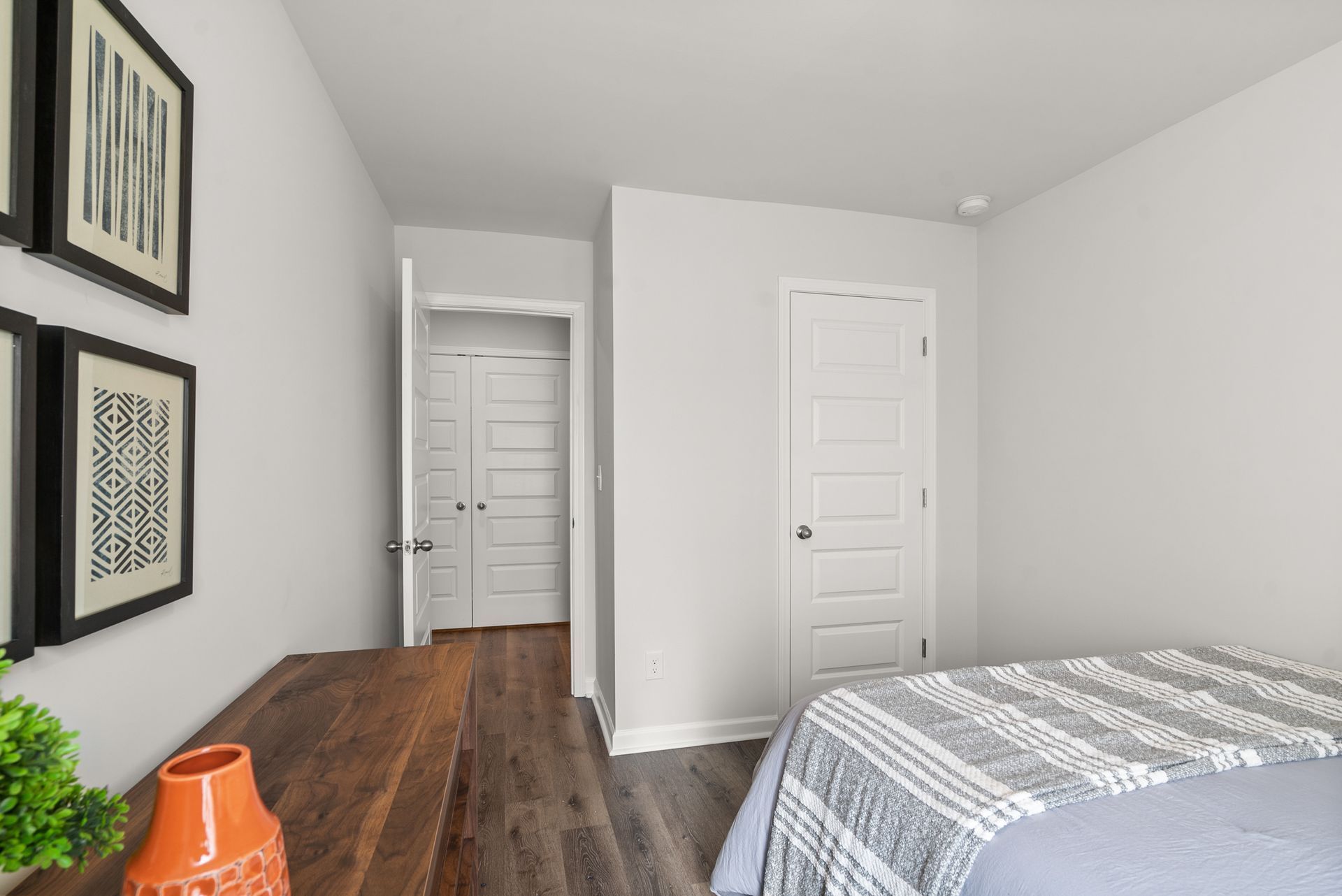 A bedroom with a bed , dresser , and closet.