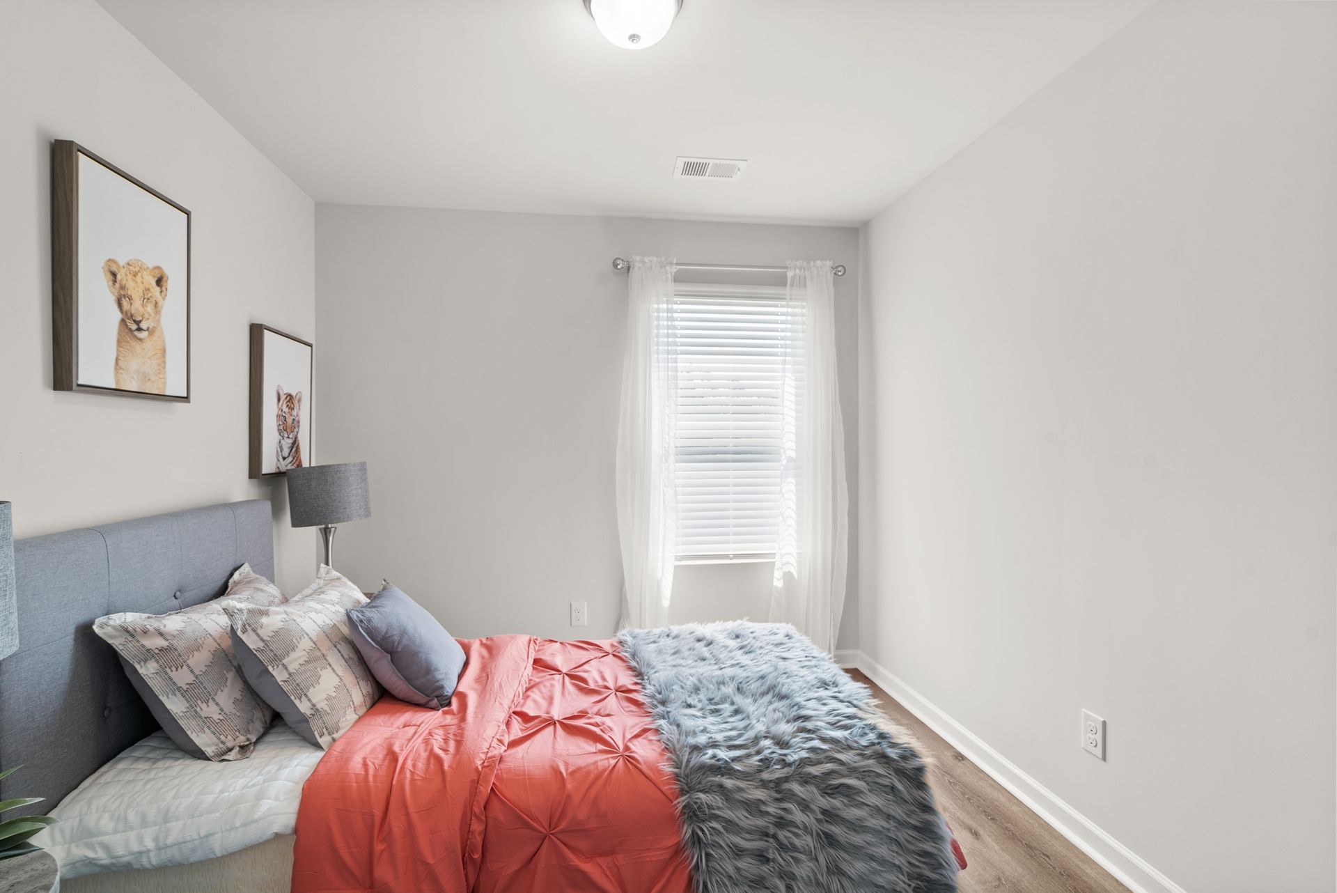 A bedroom with a bed , lamps , and a window.