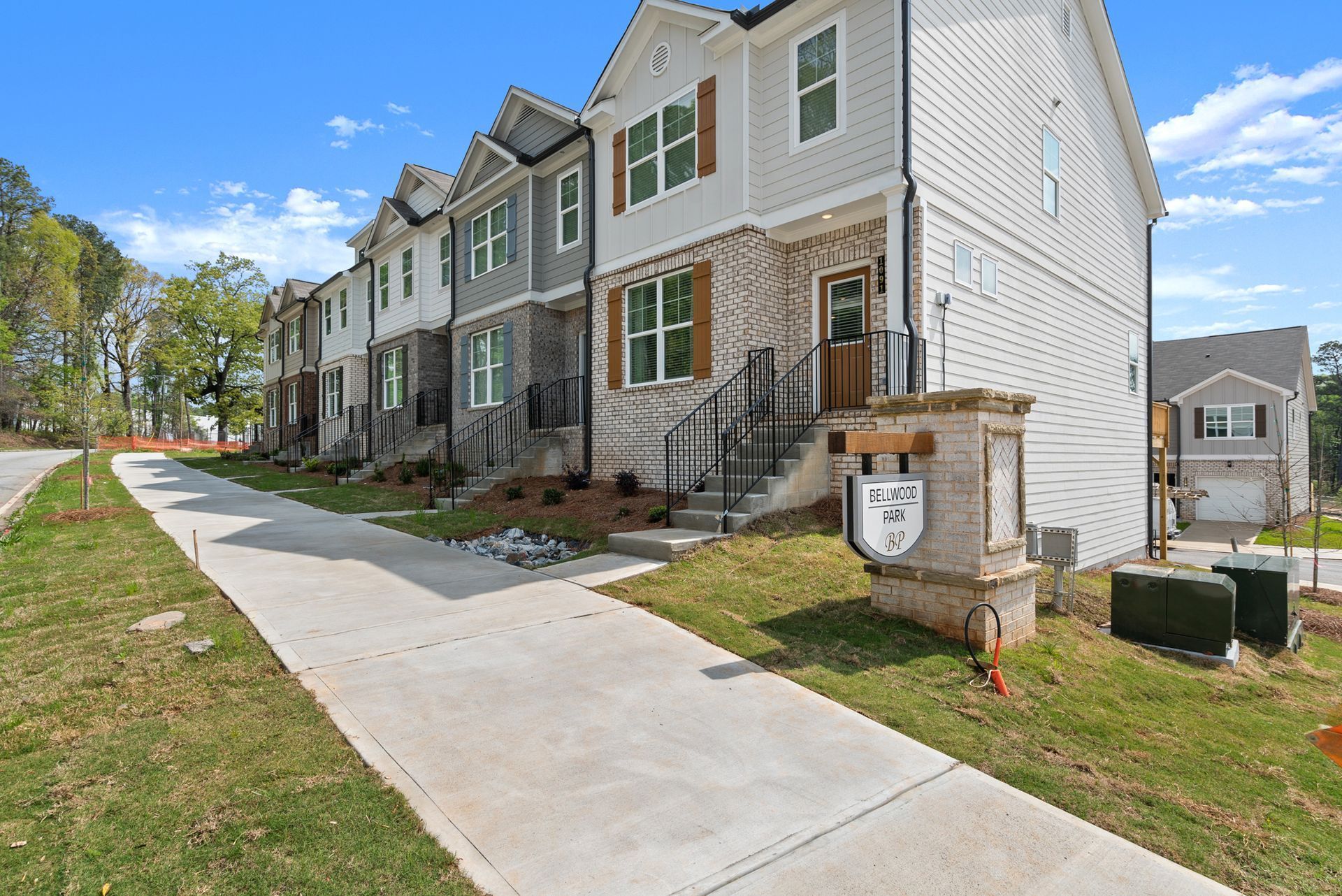 A row of houses with a sidewalk in front of them.