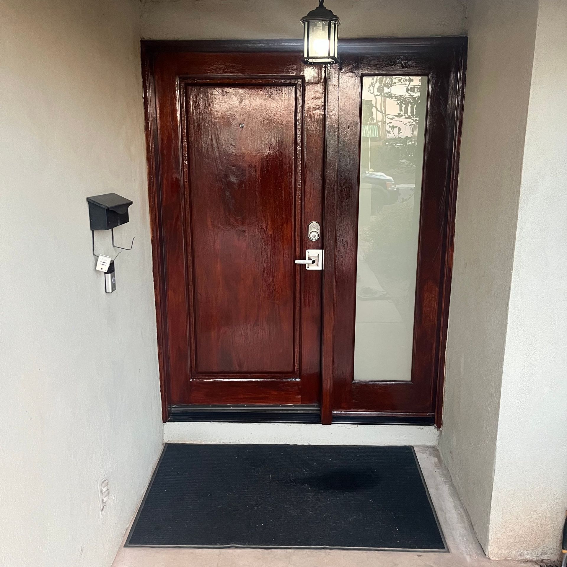 A brown door with a black mat in front of it