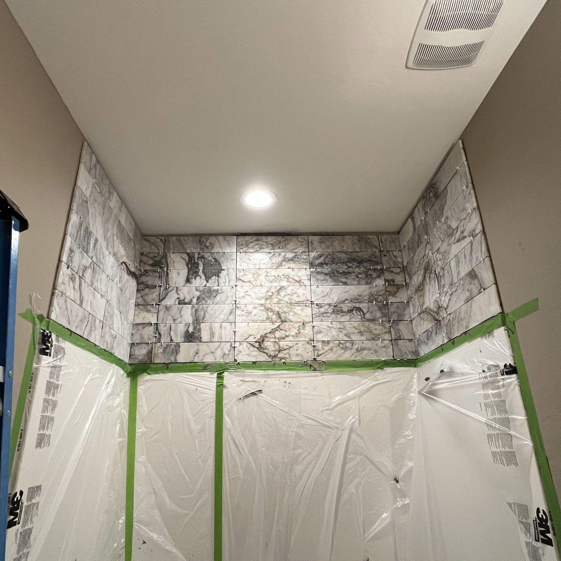 A bathroom with a ceiling that is covered in plastic