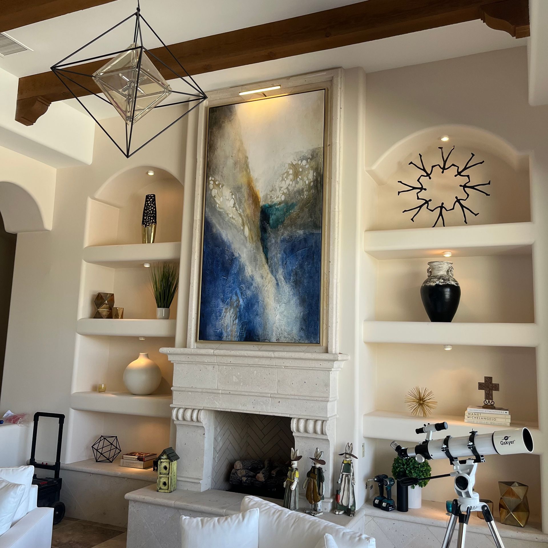 A living room with a fireplace and a painting on the wall