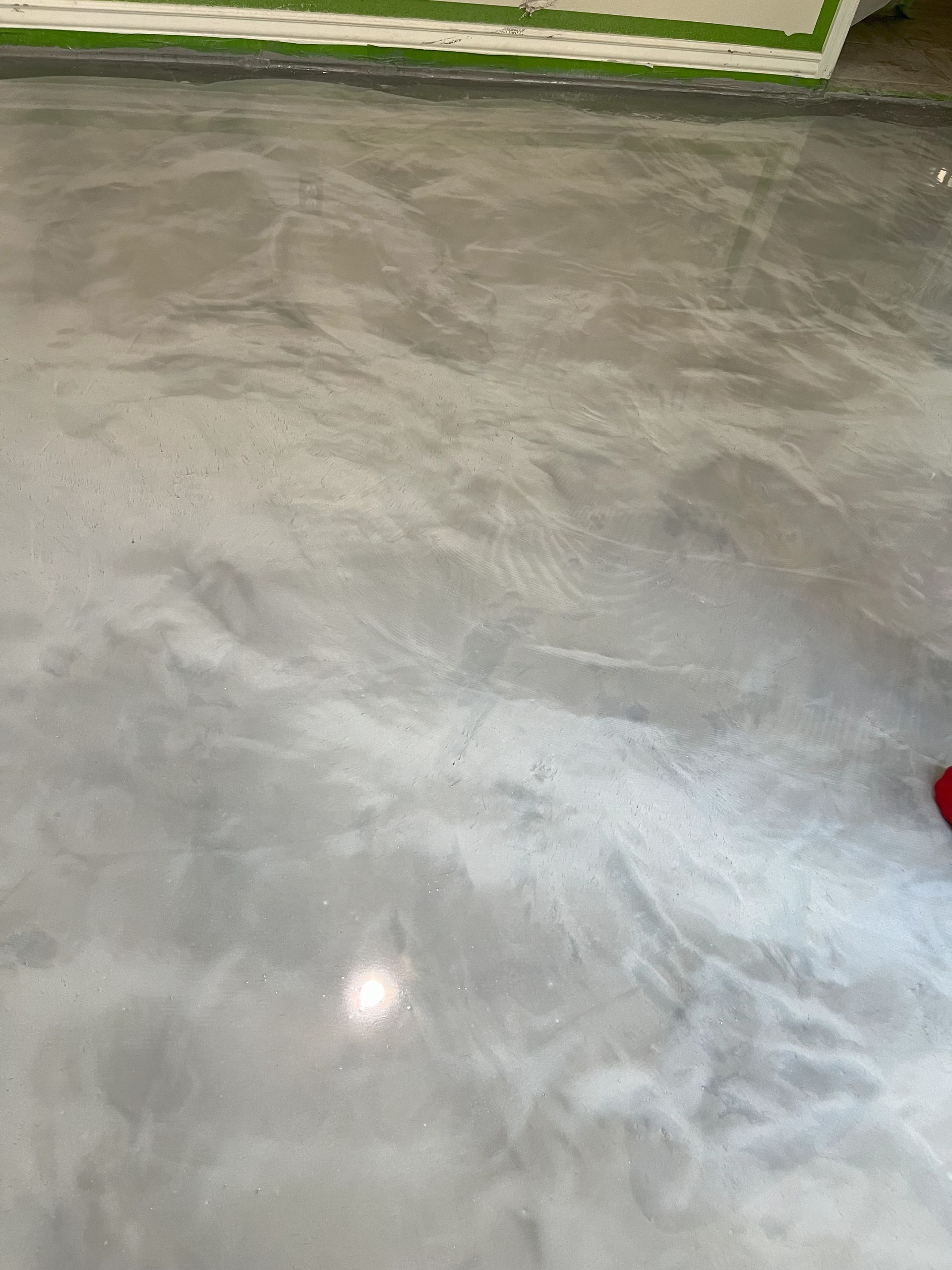 A person is standing on a gray concrete floor.