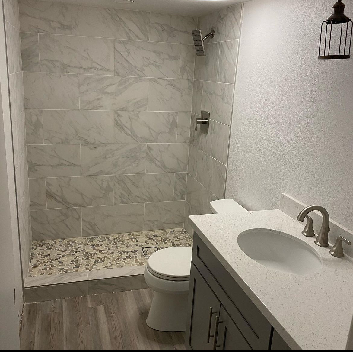 A bathroom with a toilet a sink and a shower