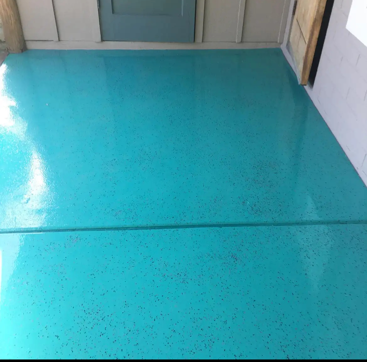 A blue floor in a room with a door in the background