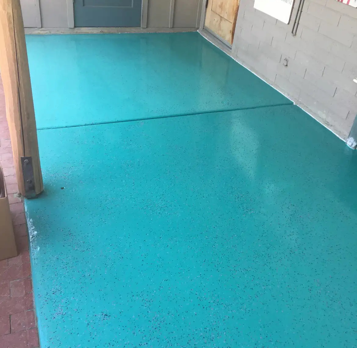 A room with a blue floor and a gray wall.