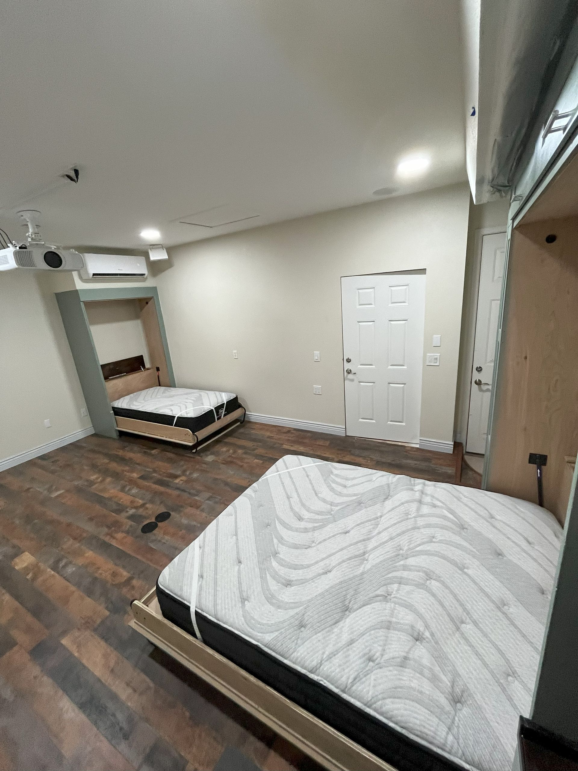 A bedroom with two beds and a mattress in it.