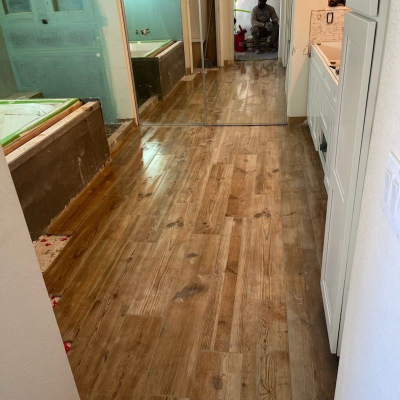 A wooden floor with a lot of tile spacers on it.
