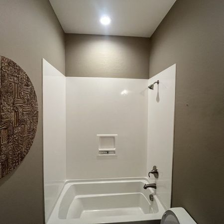 A bathroom with a bathtub and a toilet