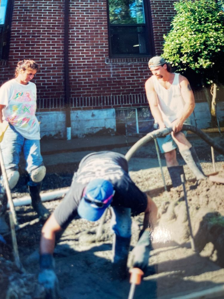A man wearing a blue hat is digging in the dirt