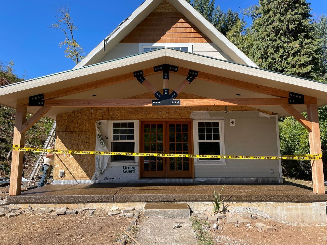 A house under construction with a wooden porch and a wooden roof.