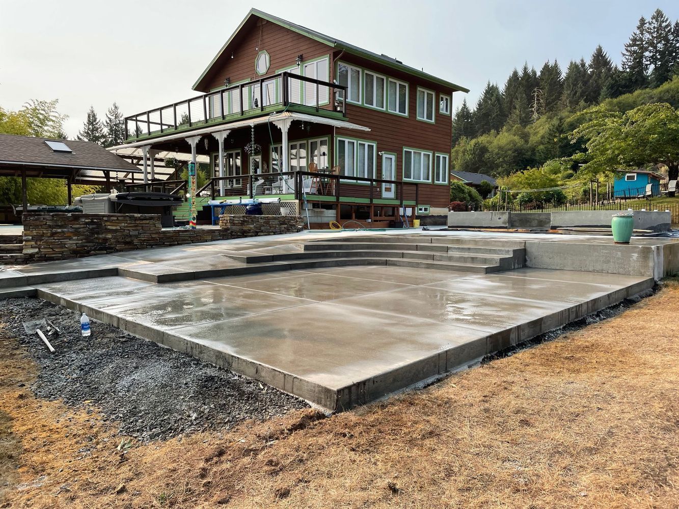 A large brick house with a concrete patio in front of it.