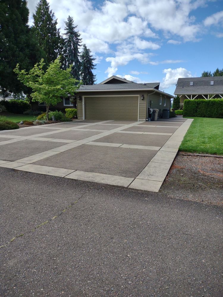 A house with a garage and a driveway in front of it.